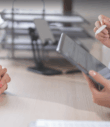 the hands of a doctor and a woman across the table in a medical clinic